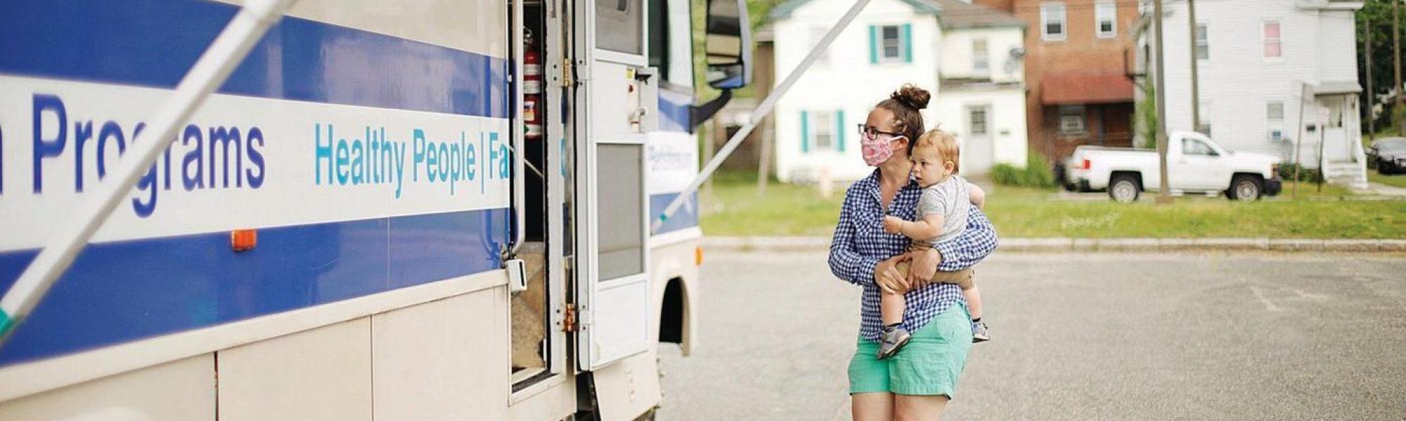 Parent going to a mobile health unit with baby